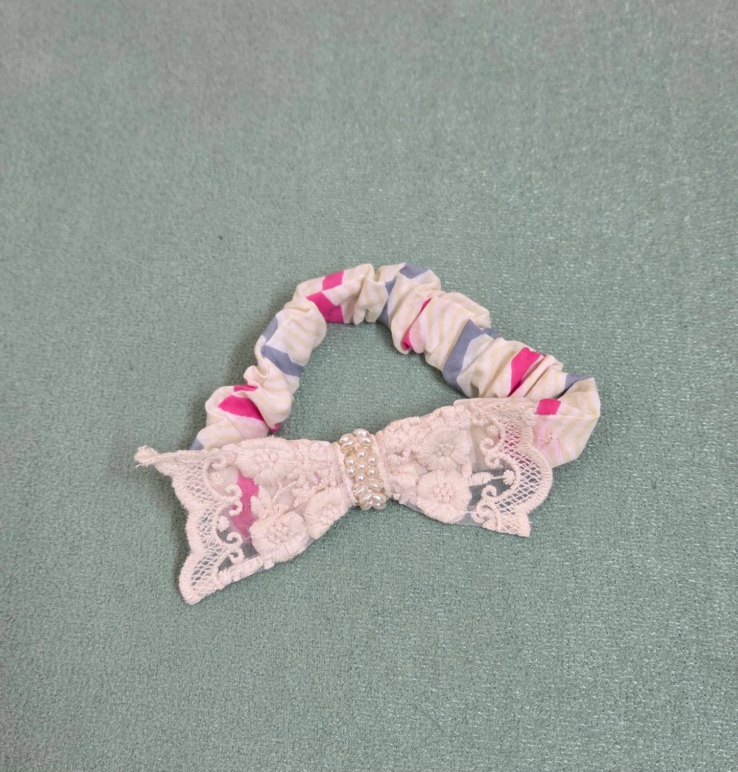 Scrunchie with a lace bow on a gray background