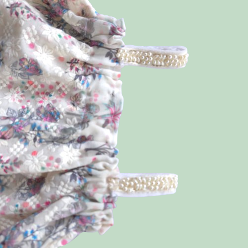 Floral dress with pearl straps on a light green background