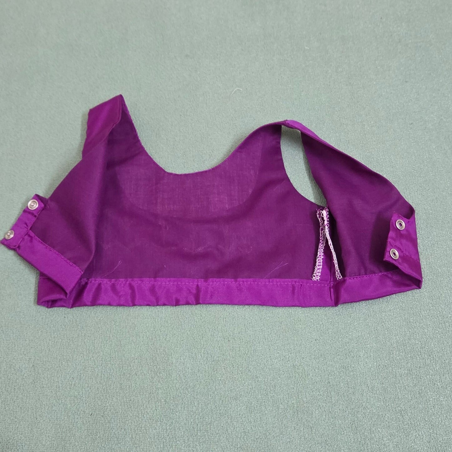 Purple crop top with button details on a gray background
