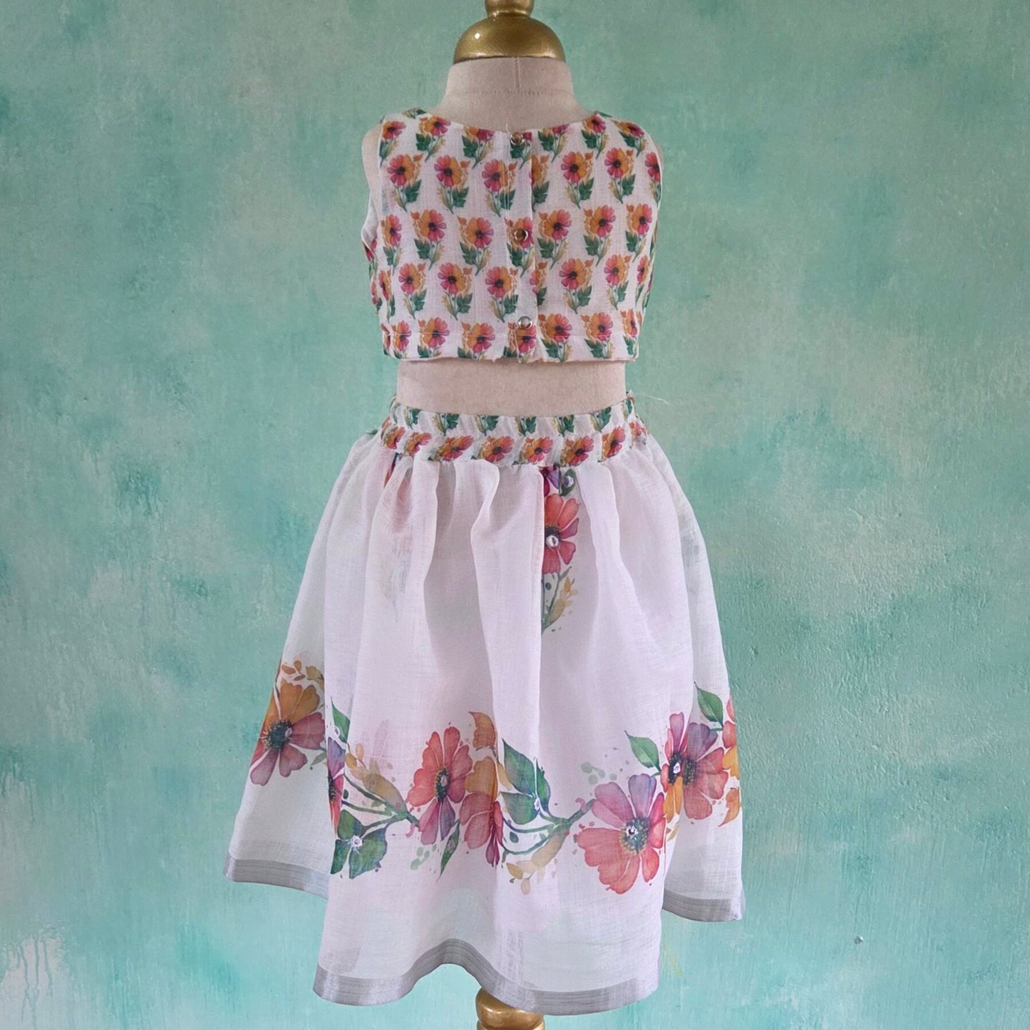 Floral dress on a mannequin against a textured teal background