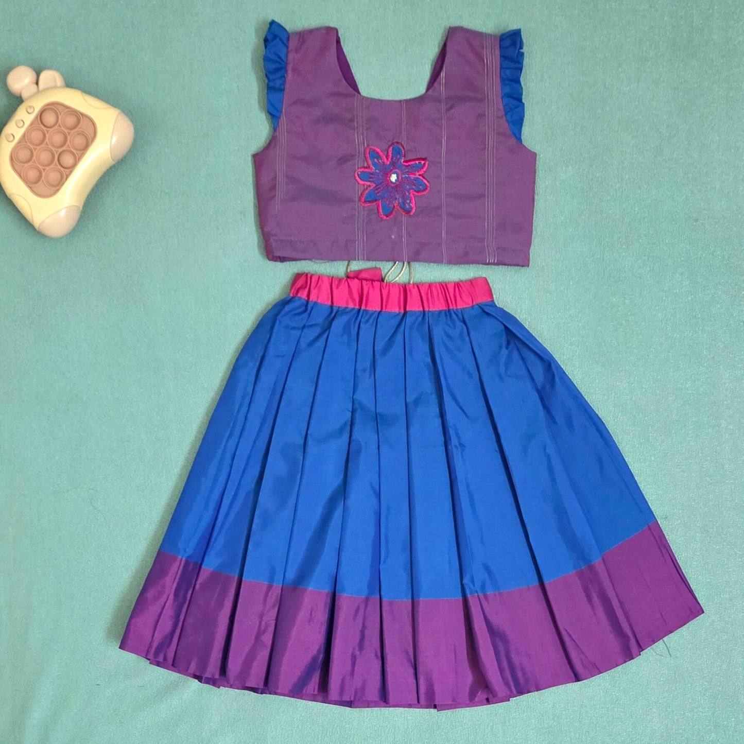 Purple and blue dress with floral design on a light green background
