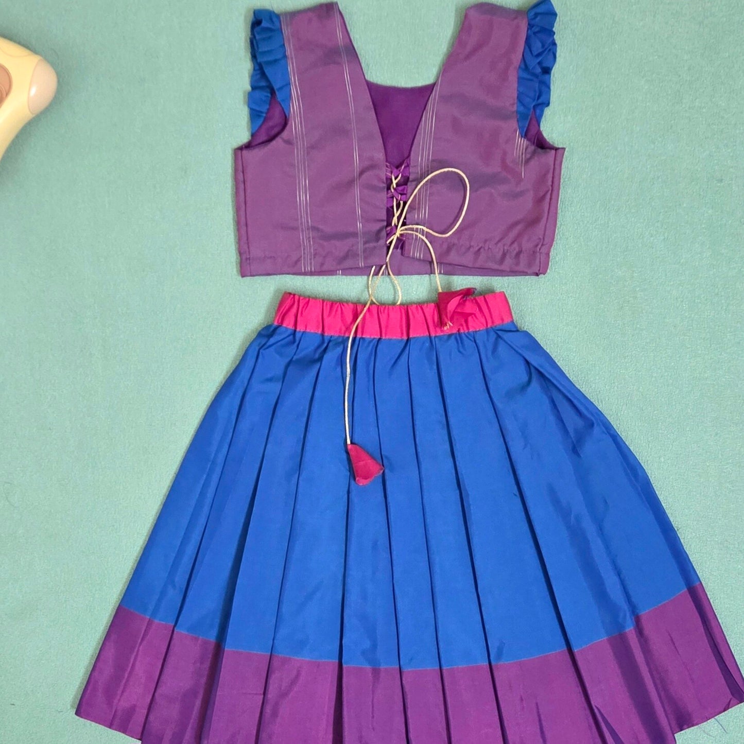Purple and blue dress with a matching top on a light green background