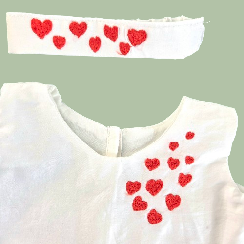 White garment with red heart patterns on a light green background