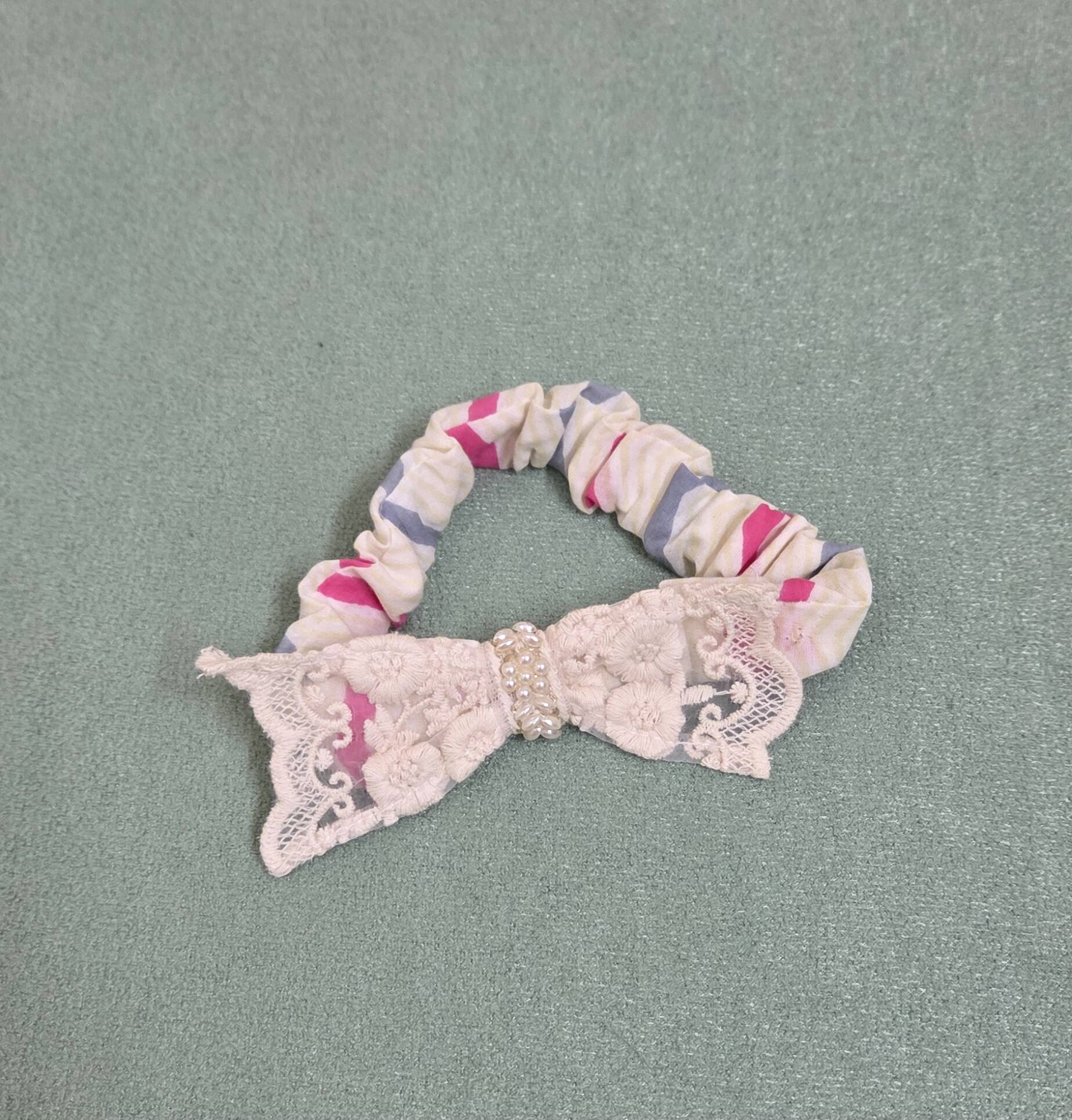 Scrunchie with a lace bow on a gray background