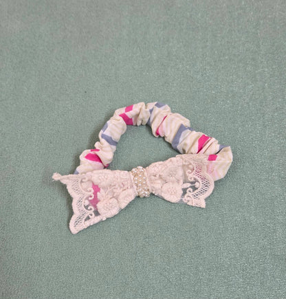 Scrunchie with a lace bow on a gray background