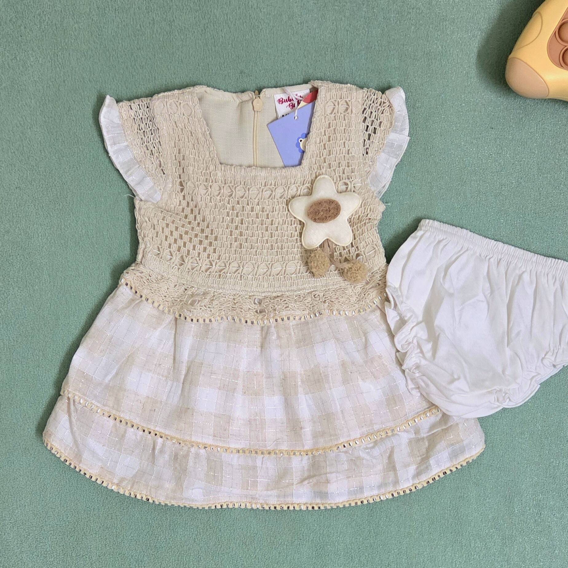 Children's dress with flower detail on a green background