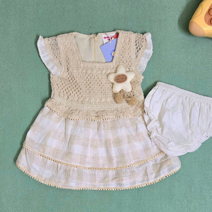 Children's dress with flower detail on a green background