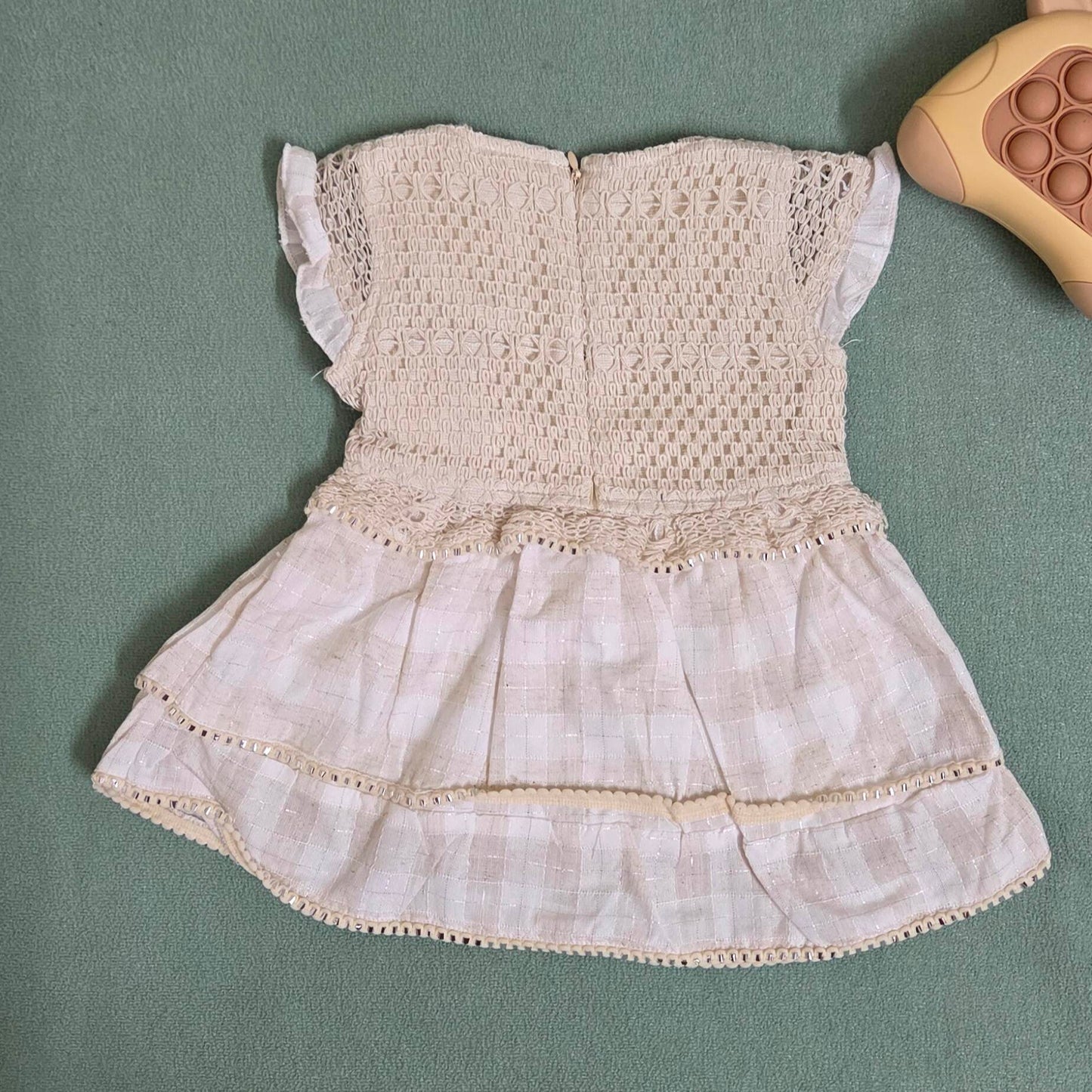 Vintage-style dress with lace details on a green surface