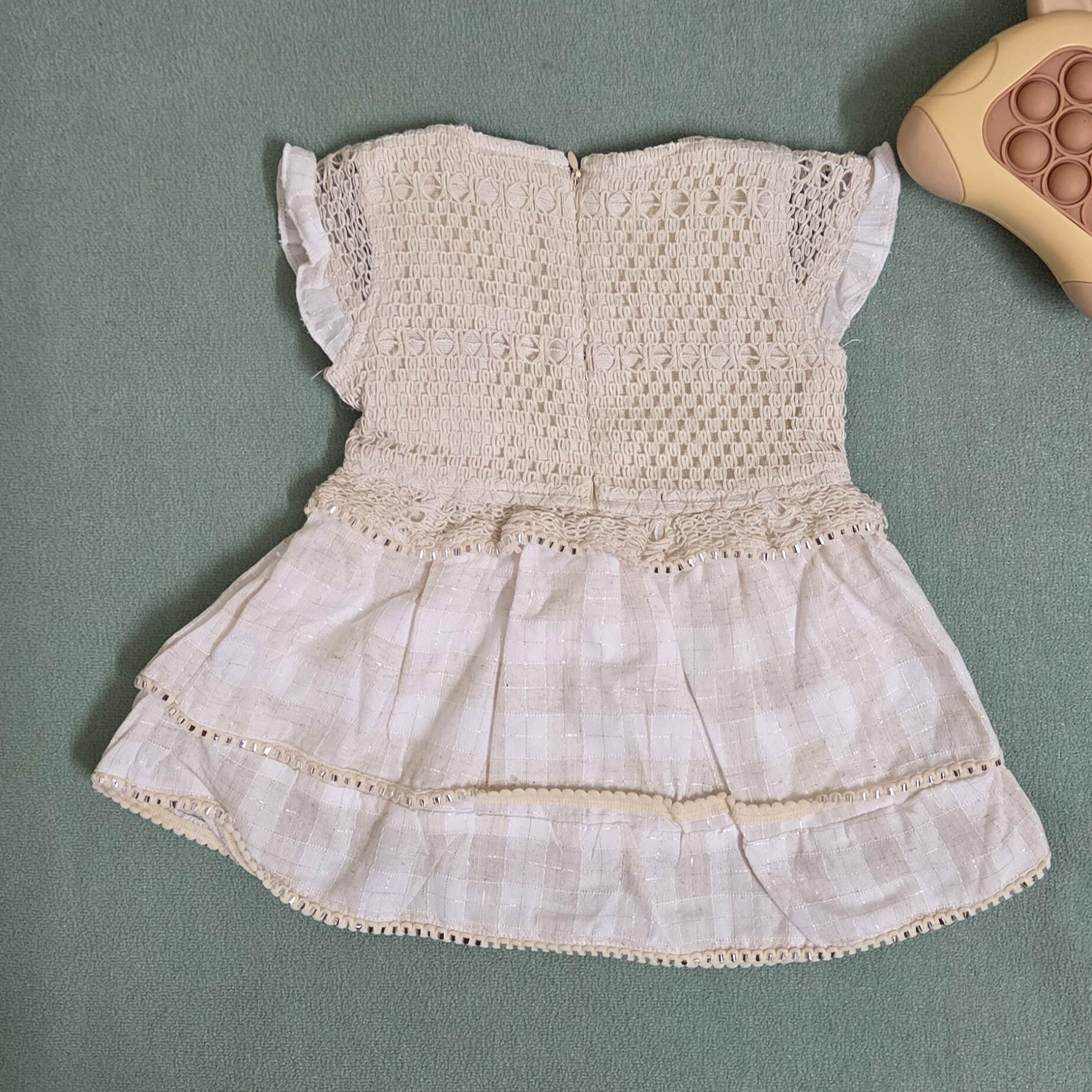 Vintage-style dress with lace details on a green surface