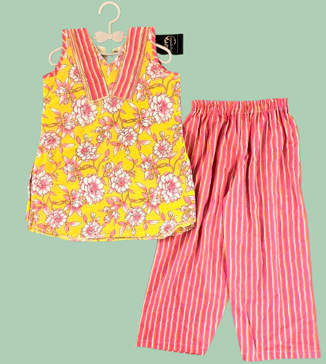 Yellow floral top and pink striped pants on a hanger against a light green background