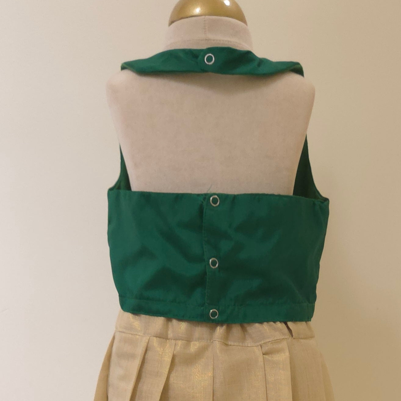Green croptop backview of halter neck on a mannequin against a beige background