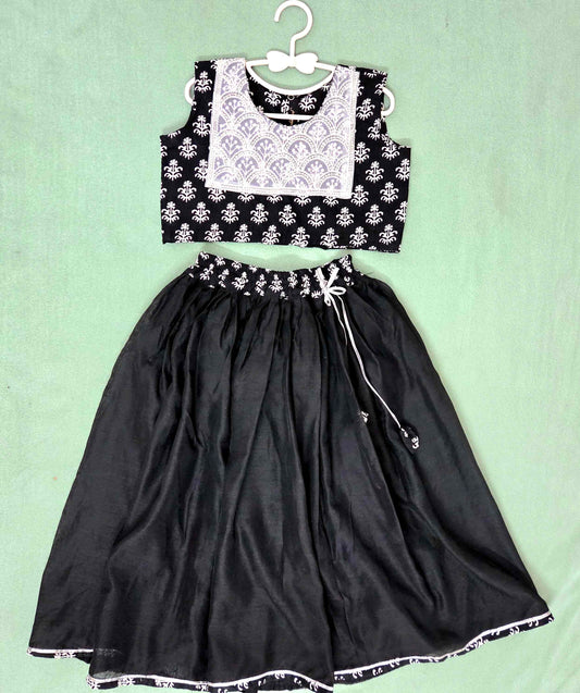Black and white outfit with a top and skirt on a light green background