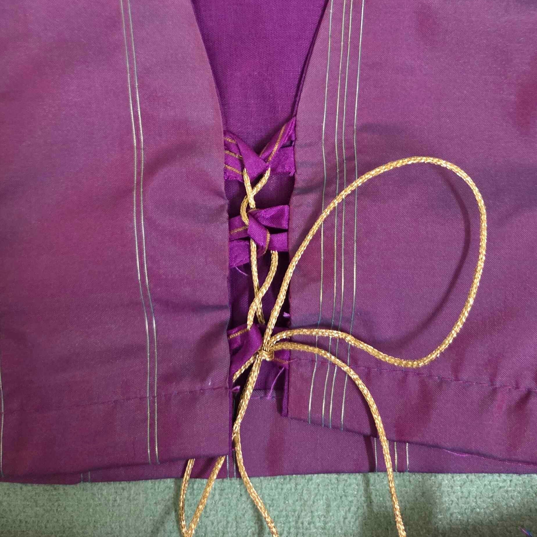 Purple crop top back with a string on a light green background