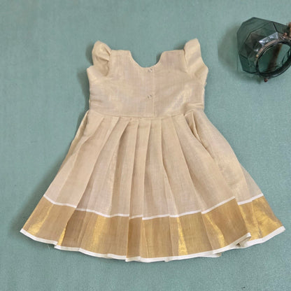 Backside view of Onam girls' frock with floral embroidery and kasavu border