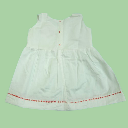 back view of White dress with red trim on a light green background
