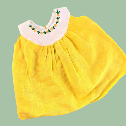 Yellow dress with white collar on a green background