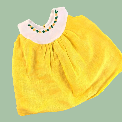 Yellow dress with white collar on a green background
