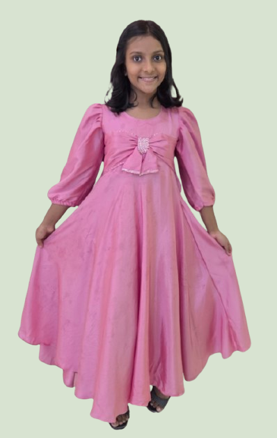 Young girl wearing a pink dress with a bow on a light green background