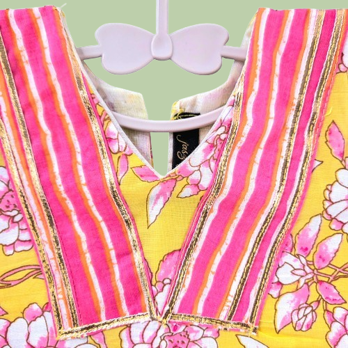 Colorful striped dress with floral patterns on a hanger against a light green background